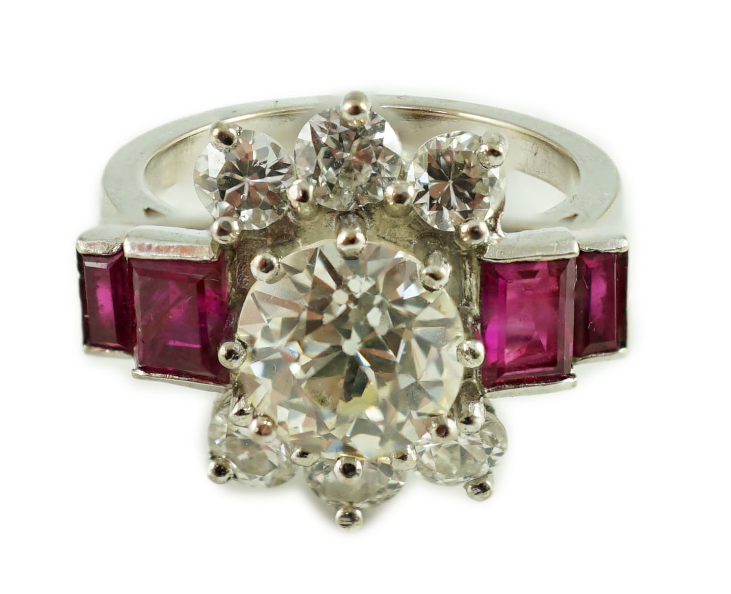 A platinum and single stone diamond dress ring, bordered by six round cut diamond and each shoulder set with two graduated rectangular rubies